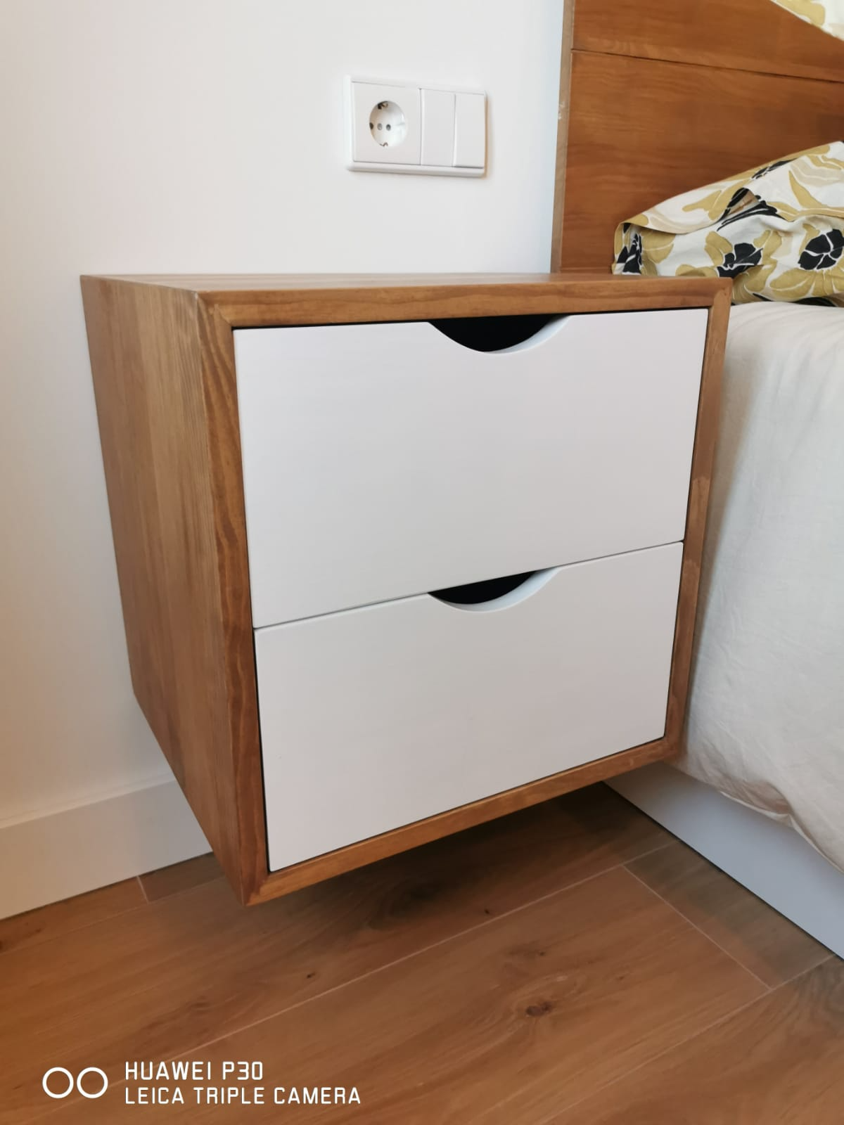 Detalle de mesita de noche de madera maciza con dos frentes blancos