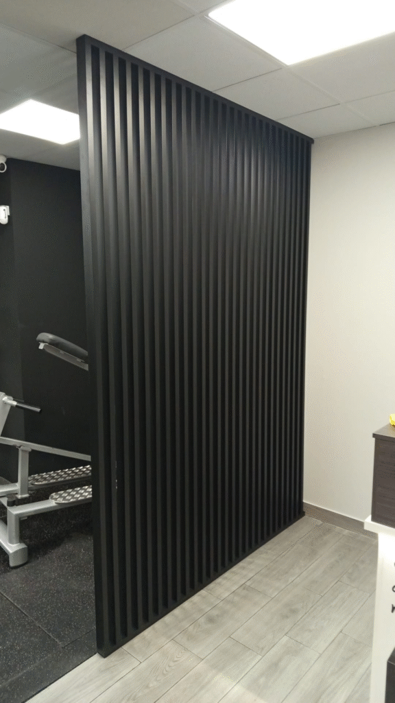 Separador de ambientes de madera maciza en color negro con listones verticales y bastidor de madera