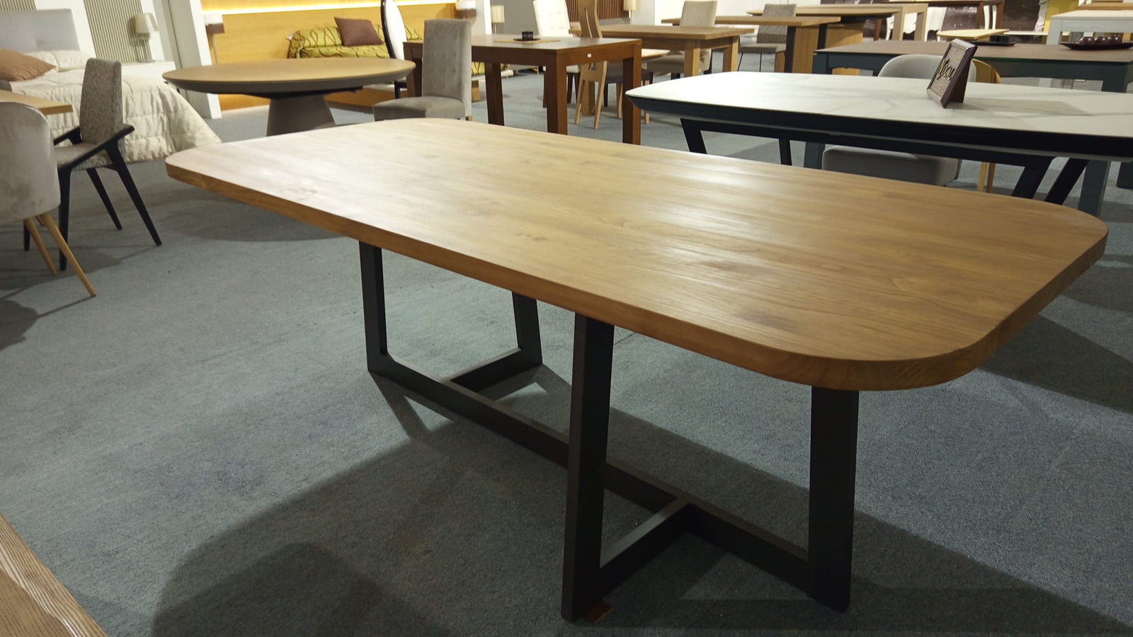 Vista en perspectiva de mesa de comedor de madera maciza con pata metálica en doble L
