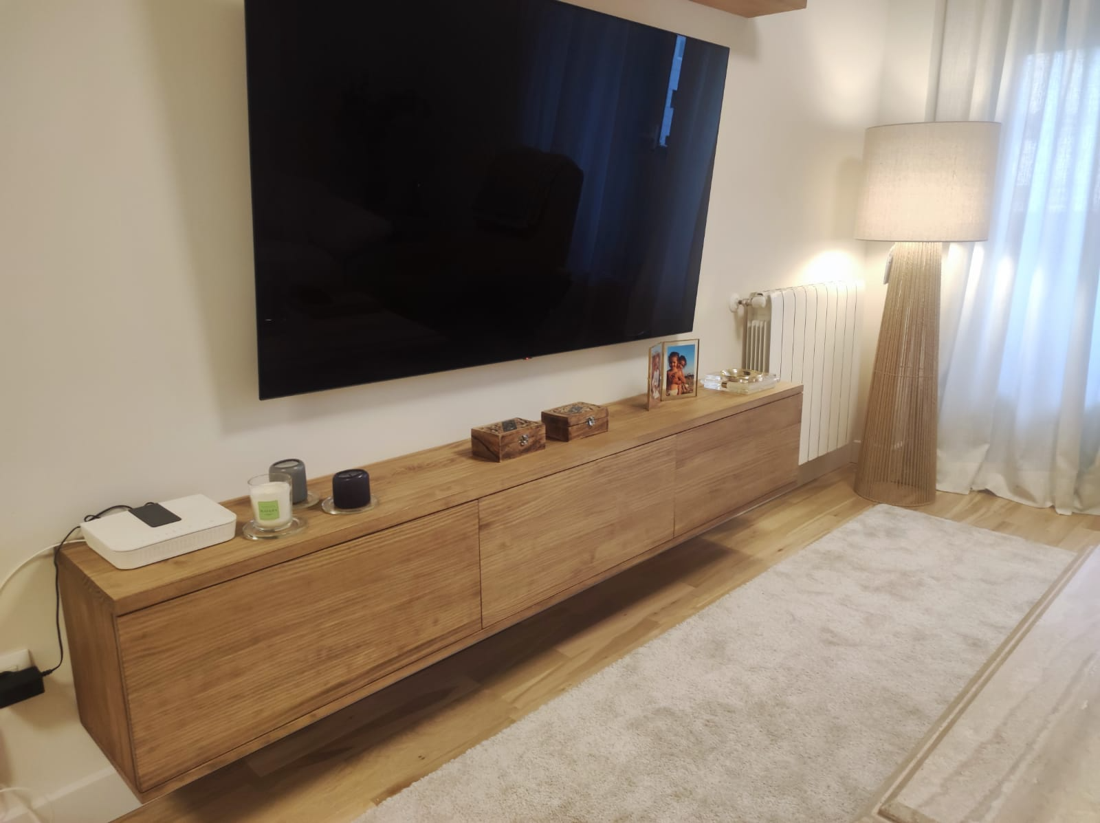Detalle del mueble TV suspendido en color nuez con tres puertas abatibles