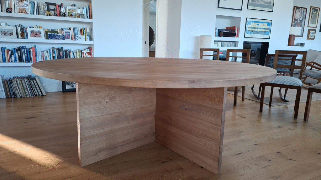 Mesa redonda de 180 cm en color nogal con patas en cruz, vista principal