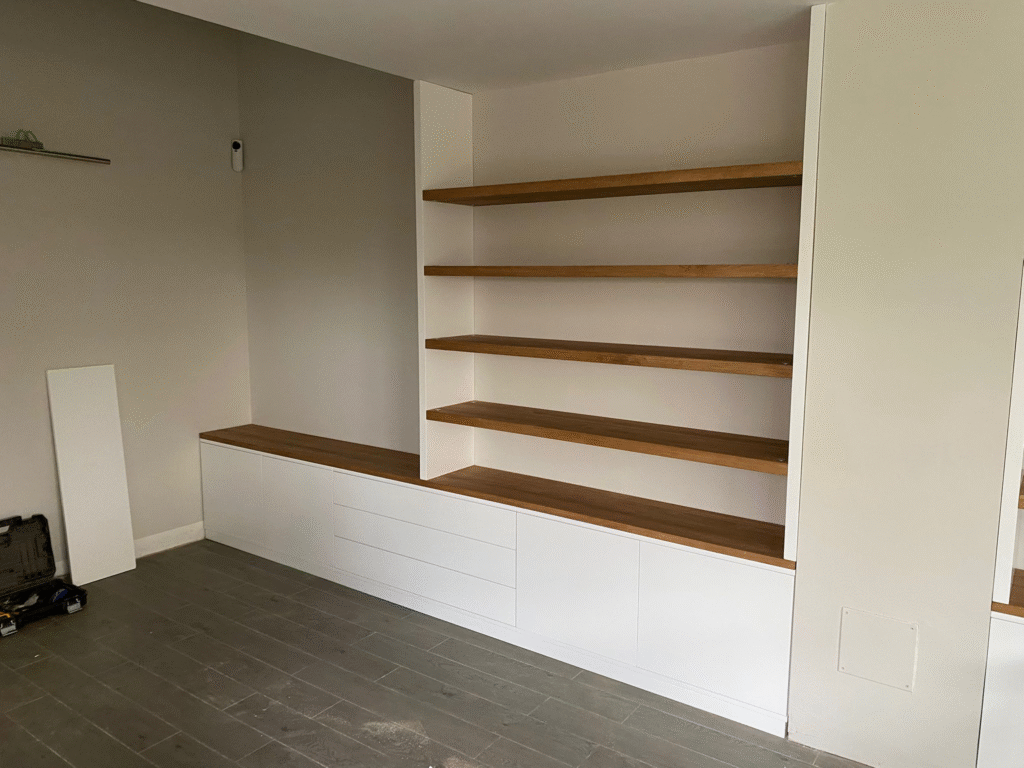 Mueble a medida lacado en blanco y combinado con roble, con baldas y almacenaje