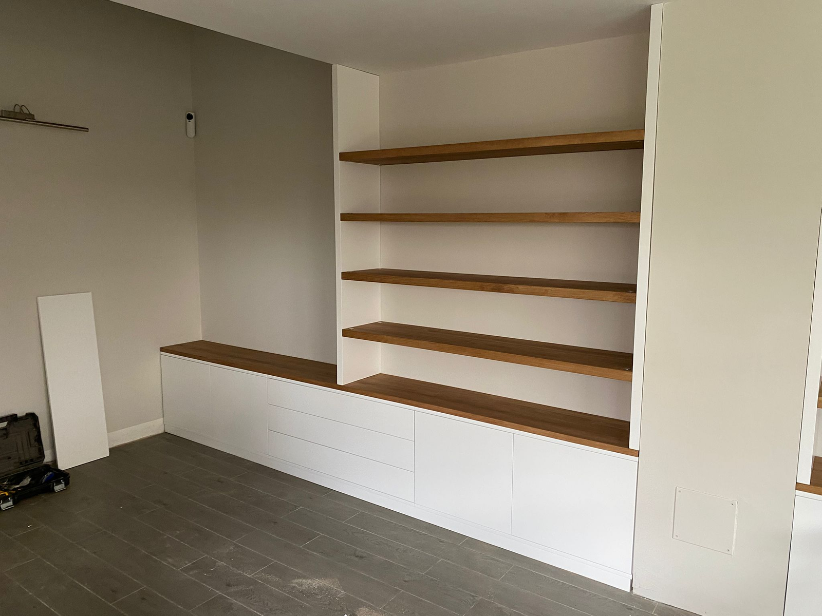 Mueble a medida lacado en blanco y combinado con roble, con baldas y almacenaje